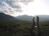 two hikers standing in a tundra field