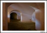 Afternoon sun shines through the embrasure openings on the white washed walls inside Fort Barrancas.