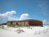 The red bricks of Fort Massachusetts located on West Ship Island, Mississippi stand out on the white sandy beach.