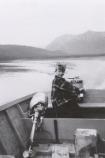 Girl in a skiff in front of her family's cabin on Lake Clark in 1952.