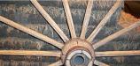 Wagon wheel with sod brick wall in background