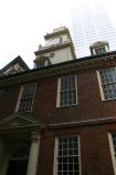 A modern building looms over the Old State House in Boston