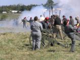 Confederate artillery soldiers stand amid the smoke of their just-fired cannon.