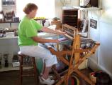 Museum volunteer demonstrates weaving loom.
