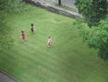 A trio of girls try their hand at an 18th-century children game by racing hoops across the green at St. Paul's Church during Colonial Day.