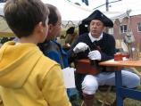 A re-enactor demonstrates how to create a quill pen from a goose feather during the Battle of Pell's Point Encampment at St. Paul's Church NHS.