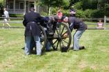 Staff and volunteers in period clothing assemble the mountain howitzer as part of a special program on the park's Parade Ground.