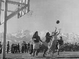 Basketball games are part of the regular scheduled recreational events, which help to fill out the lives of residents in relocation centers. These girls are participating in a nip and tuck game, which frequently brought the spectators to their feet.