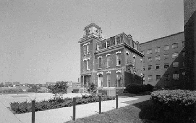 Black and white photograph of Howard Hall with modern building behind it 