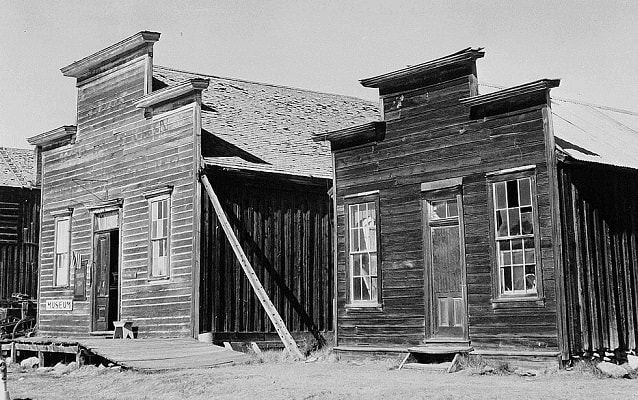 Black and white photo of two one-story buildings. 