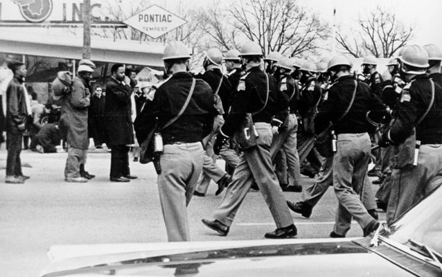 black and white photo of police approaching marchers