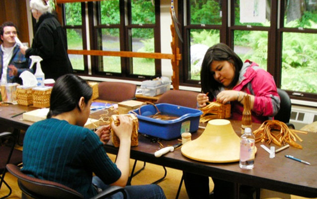 Students weave spruce root baskets in the park's regalia studio.