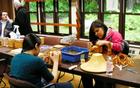 Students weave spruce root baskets in the park's regalia studio.