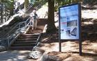 An upright orientation exhibit near a granite staircase