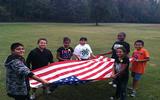 Kids from the Boys and Girls Club learn to fold the falg.
