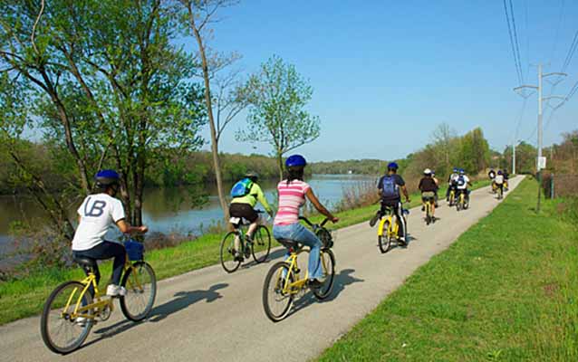 High school students bicycle along a beautiful paved trail along the Schuylkill River.