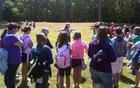 Park ranger gestures toward earthworks while talking to students
