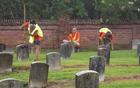 Image of volunteers scrubbing headstones at a national cemetery