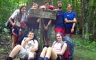 A group of young backpackers poses by a trailhead sign in the park.