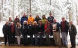 Group picture of teacher workshop participants standing in front of snowy woods.