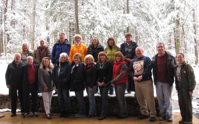 Group picture of teacher workshop participants standing in front of snowy woods.