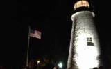 Nightime view of lighthouse with American flag