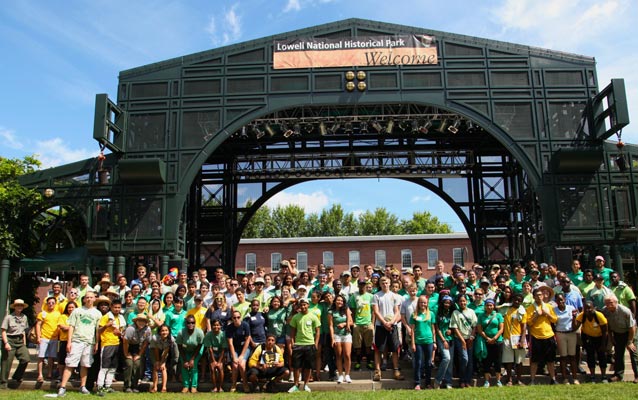 Youth participants gather for a group photo at an outdoor stage