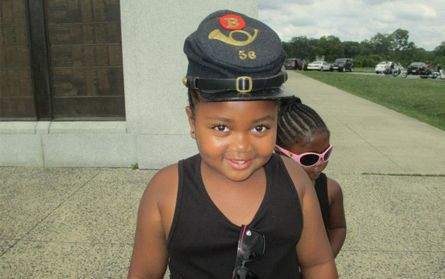 Two young visitors, one wearing a Civil War-era hat