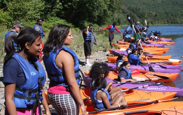 Students standing by kayaks on the Delaware River