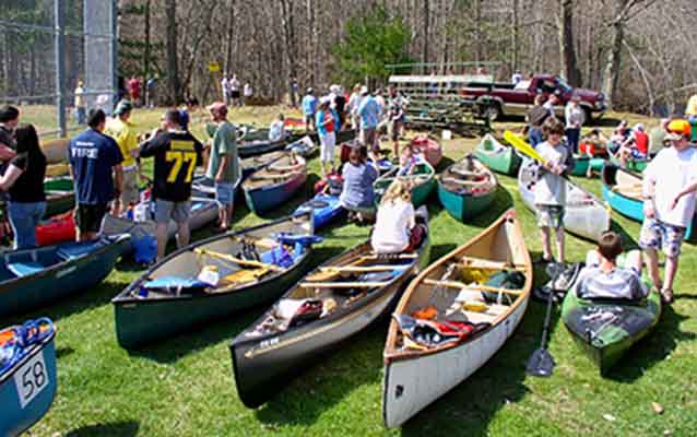 Assembling at a baseball field, a group of canoers get ready to embark.