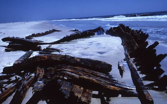 A shipwreck exposed in the surf after a storm.