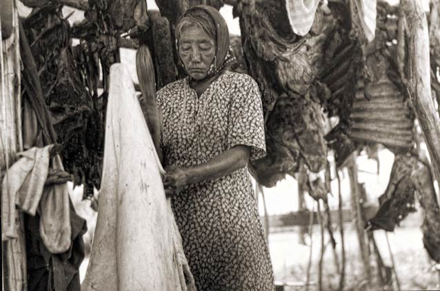 woman surrounded by pieces of drying moose and hide