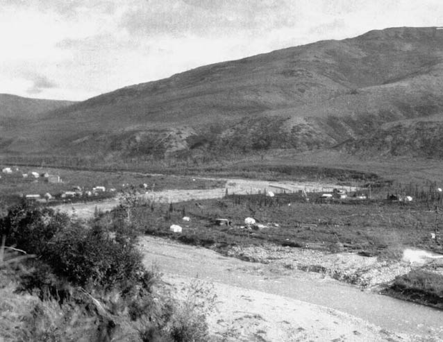 black and white image of a hill overlooking a river valley with scattered buildings
