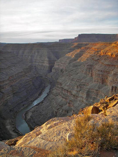 A river winds through a canyon, viewed from the canyon rim