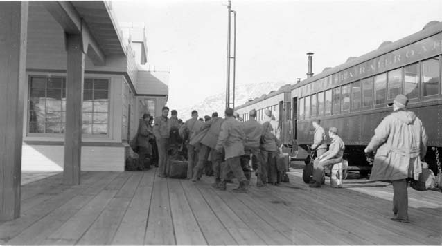black and white image of soldiers at a train depot