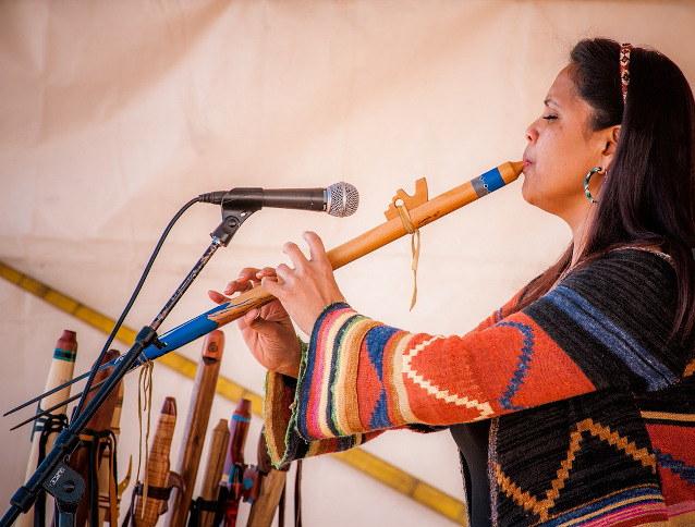 An American Indian woman plays the flute at the American Indian Arts Festival