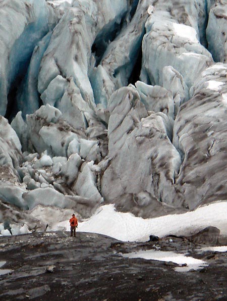 man dwarfed by a giant glacial moraine