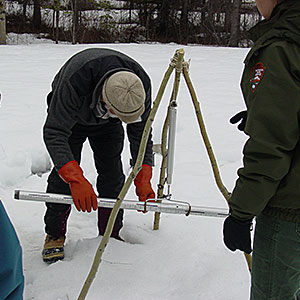 Scientists measure snow to determine rate of change.