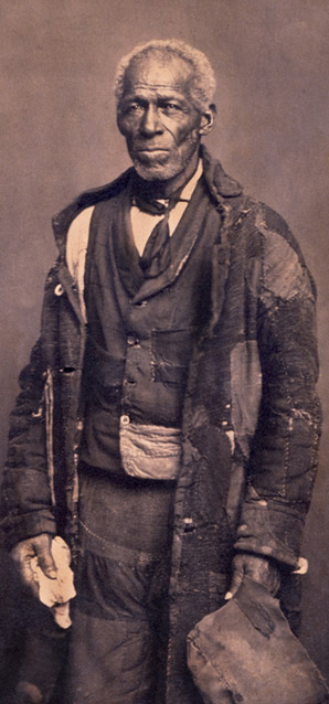 Photograph of sailor George Roberts, wearing tattered clothes