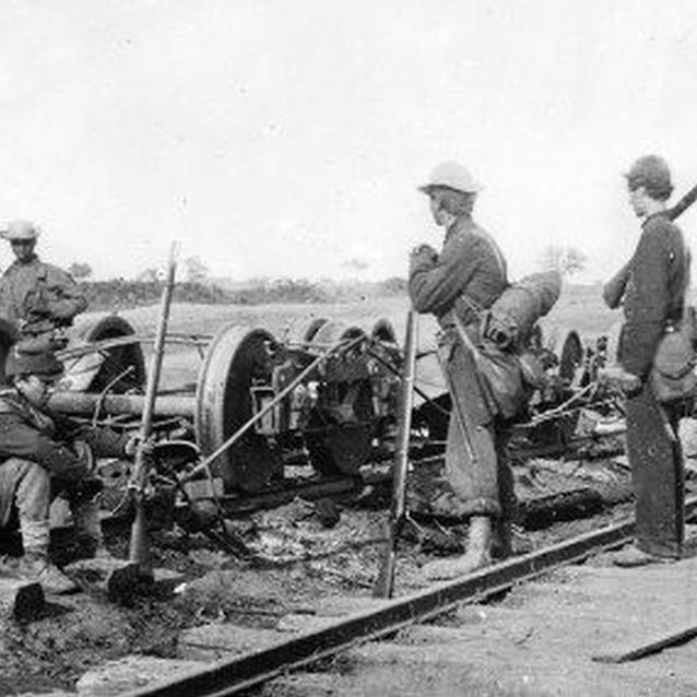 Three Union soldiers and one African-American civilian pause over a collection of railroad trucks on the Orange and Alexandria Rail Road line.