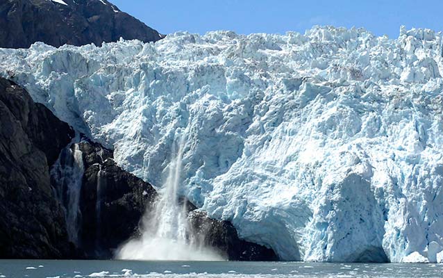 Enormous tidewater glacier, with a piece of a glacier calving, or falling, into the ocean