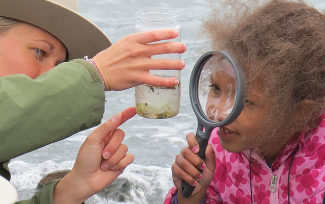 A ranger and child examine a water sample