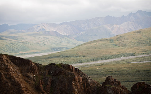 distant sheep on a mountain, river valley and other mountains in background