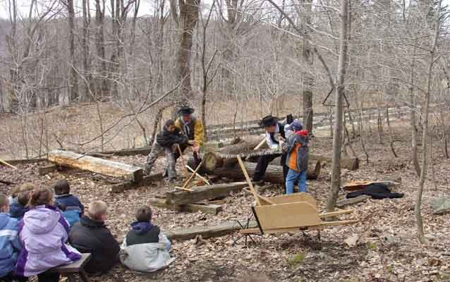 Rangers and students hew a log
