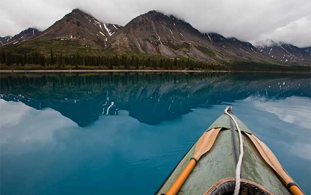 Canoe on lake surrounded by mountains