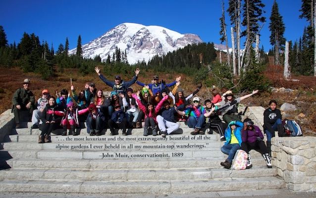 A Mount Rainier Institute student group poses in front of Mount Rainier on the steps near the Jackson Visitor Center in Paradise.