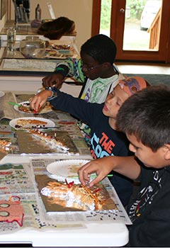 three kids working at arts and crafts three kids working at arts and crafts