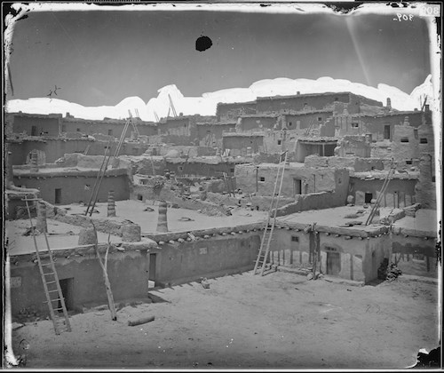 Black and white photo of Zuni Pueblo, earthen architecture with wooden ladders