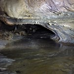 a shallow river lies beneath a rock formation, River Styx at Oregon Caves National Monument and Preserve