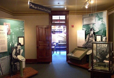An interior room at a house showing some displays on the left and right with a door in the center.